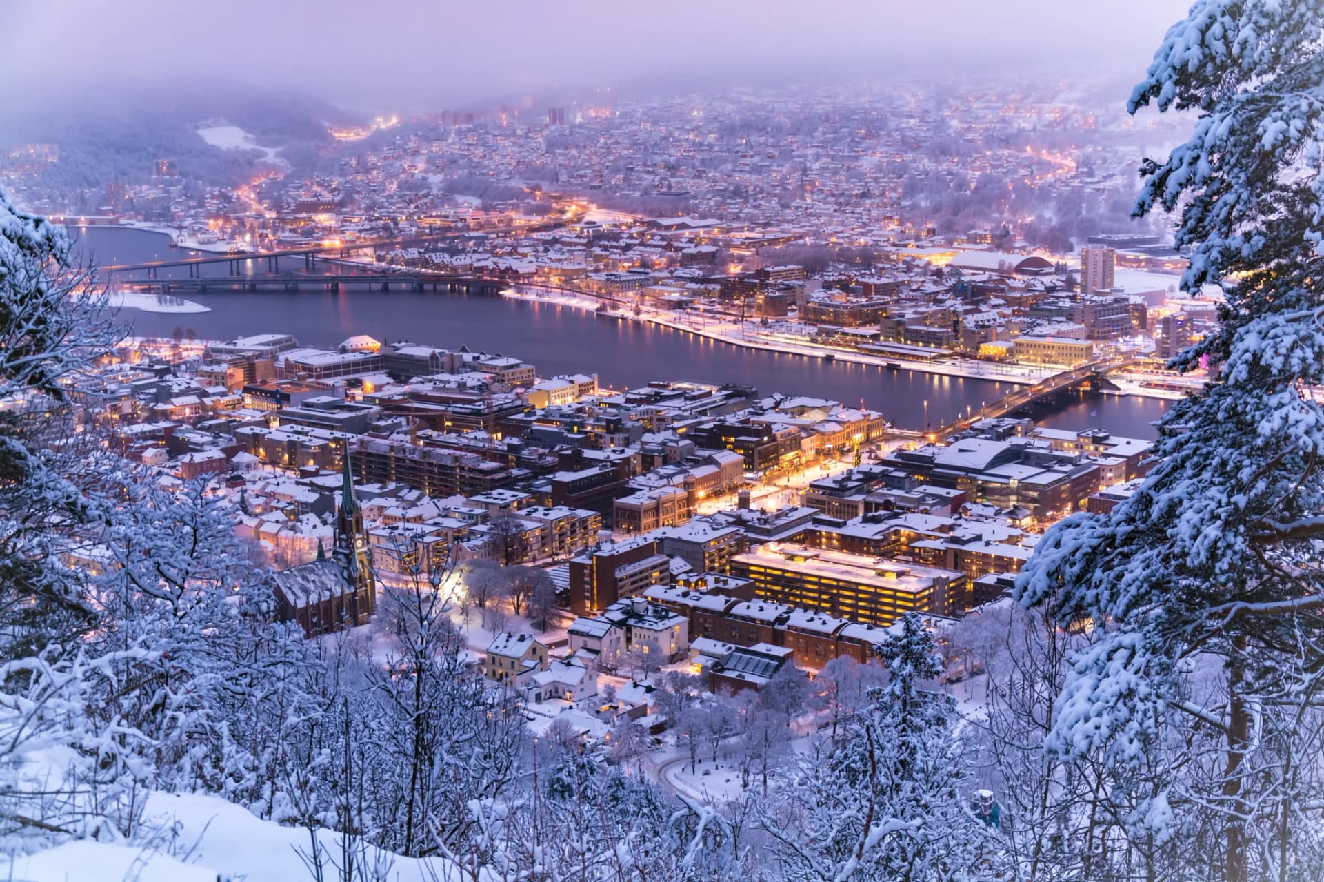 Vista invernal de Drammen con el río congelado y la ciudad nevada