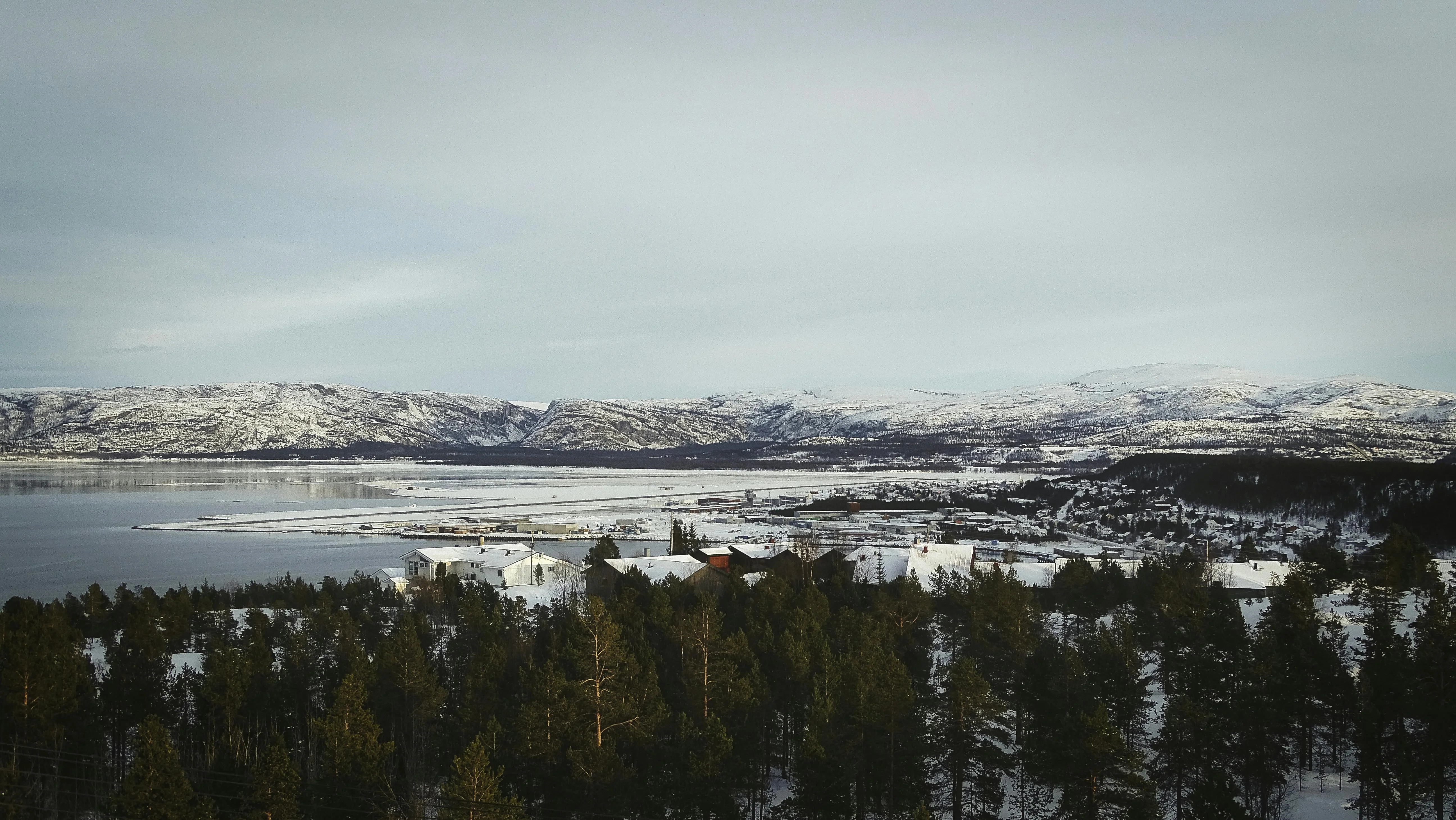 Paisaje invernal de Alta con montañas nevadas bajo el cielo ártico